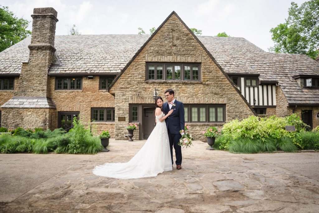 A bride and groom pose for wedding portraits in front of Groesbeck Estate in Cincinnati Ohio