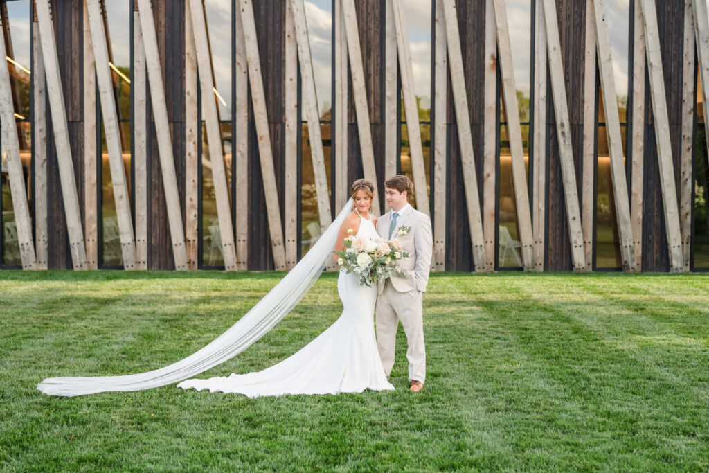 Bride and Groom stand in front of the Arboretum at the Gardens at Jorgensen Farms